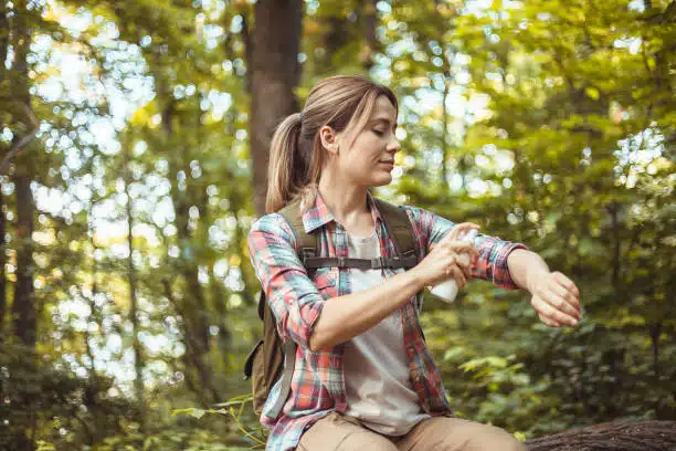 woman spraying insect repellent during hiring